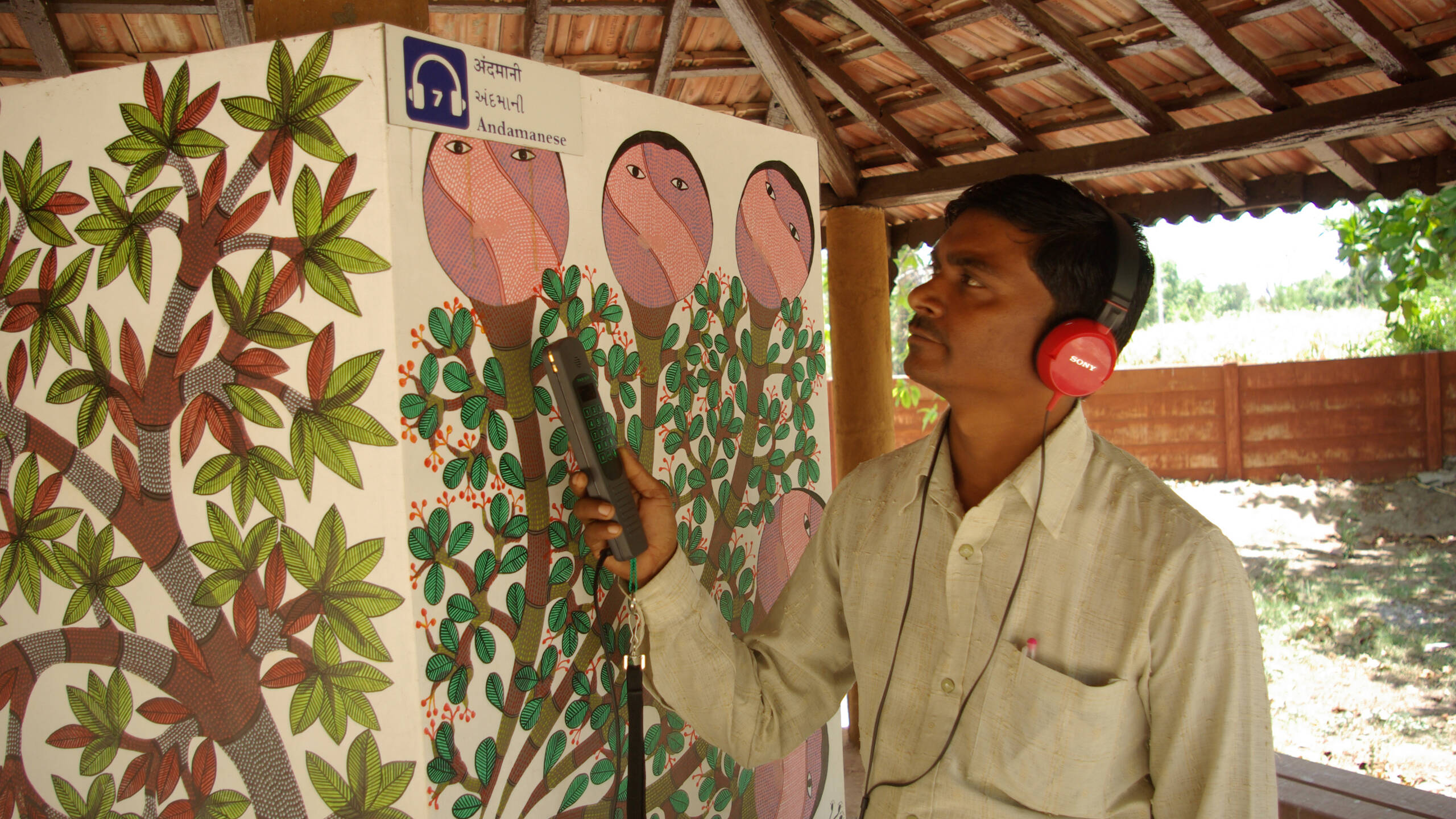 A visitor listening an audio tour at Bhasha Van