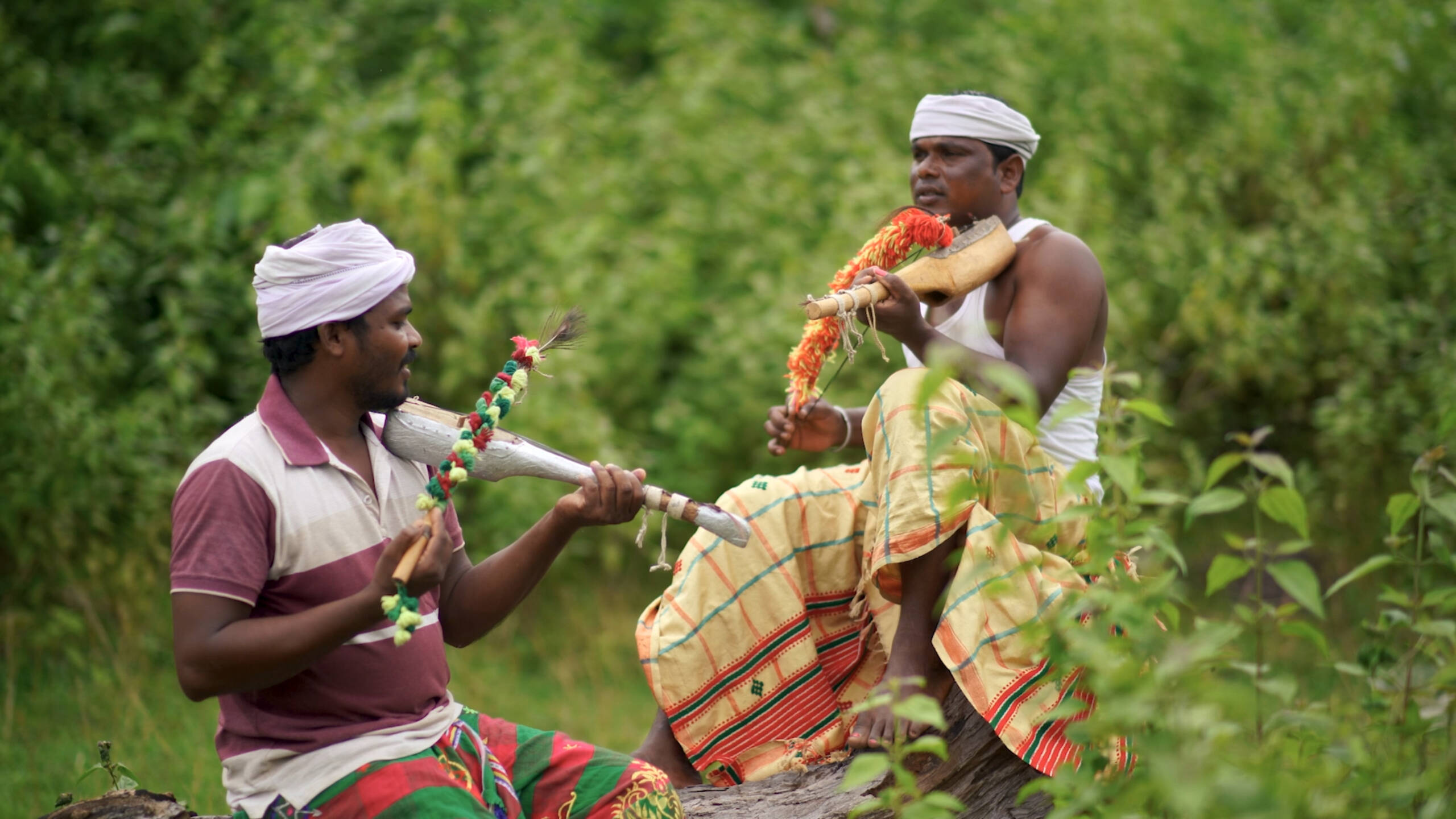 Santal men playing musical instrument known as Banam