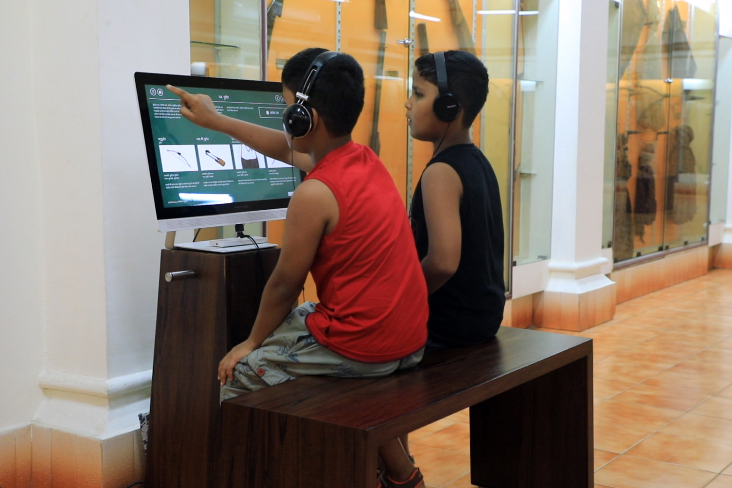 Two boys interacting with touch screen kiosk